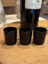Load image into Gallery viewer, Three black horn shot glasses on a wooden board.
